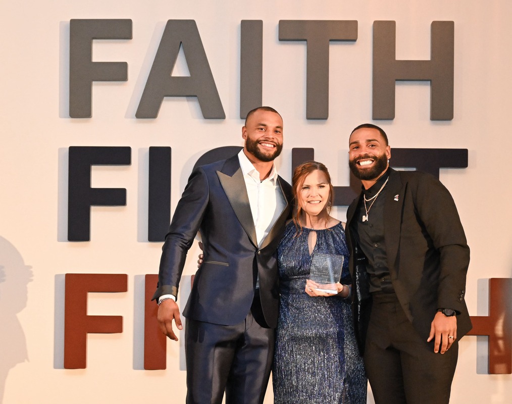 people posing for photo with faith fight finish logo in background