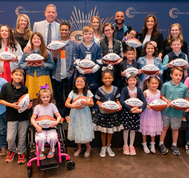 Group of children holding footballs at charity event